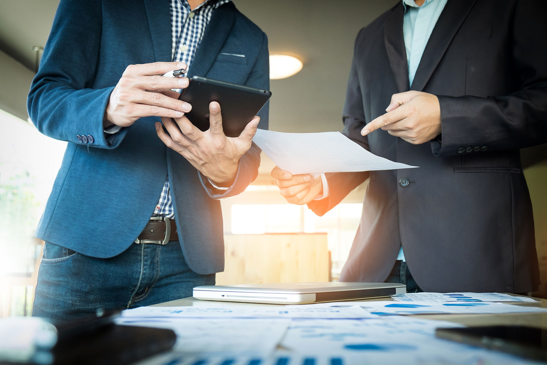 people reviewing information on tablet and document